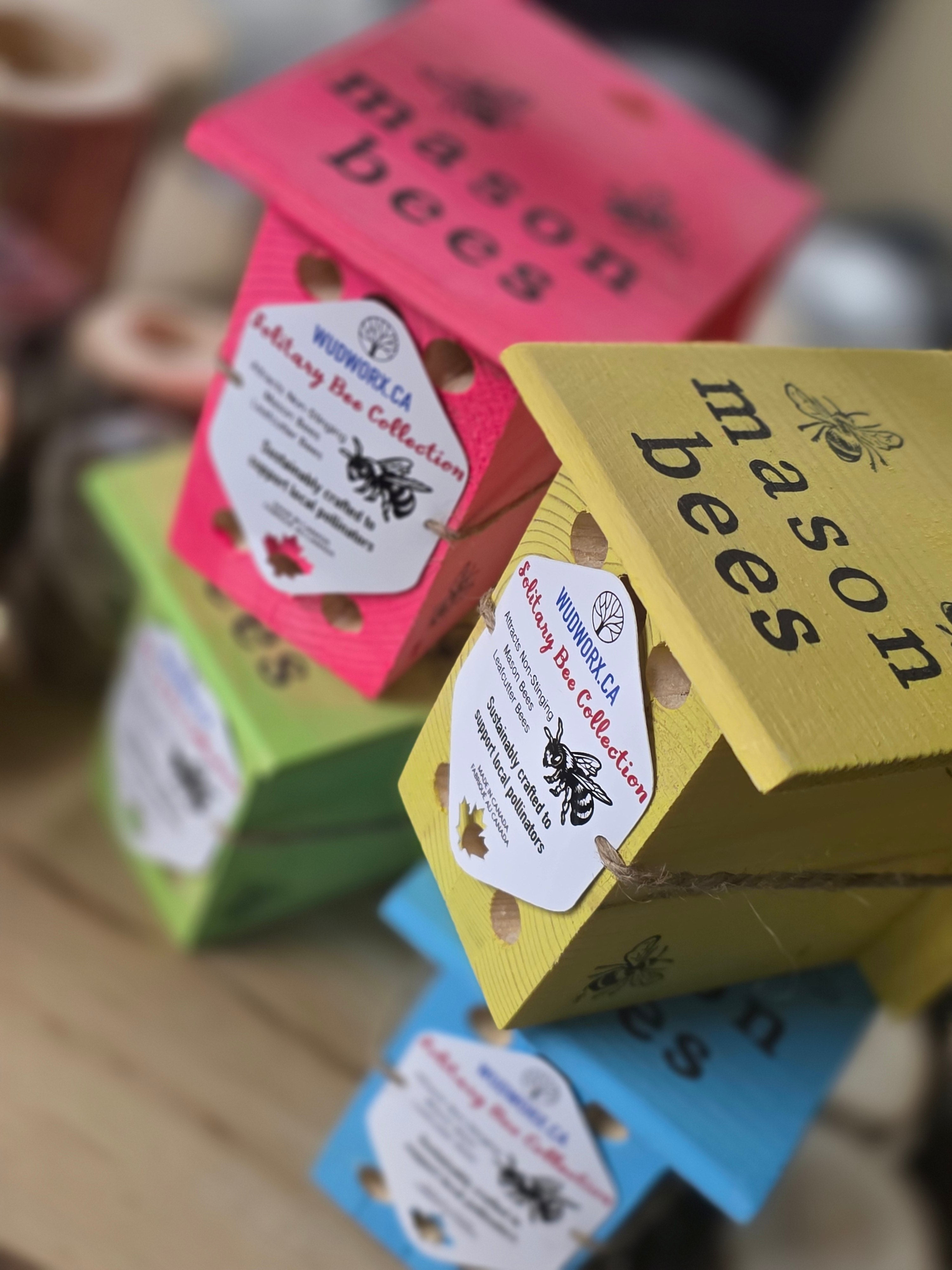 mason bee homes in vibrant colors of yellow, hot pink, blue, green for yard decor and pollinator bees.